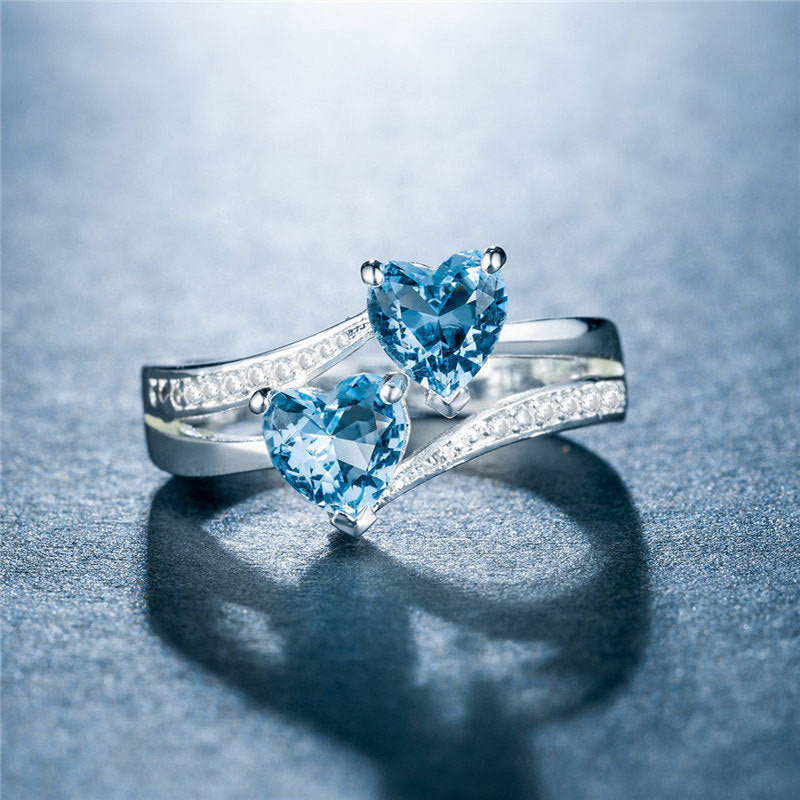 Damen herzförmiger Ring mit funkelnden Zirkonia und zwei blauen Edelsteinen Shop Nory