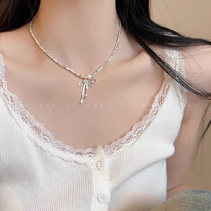 Damen Halskette mit zierlichem Schleifenanhänger und verspielten Perlen Shop Nory