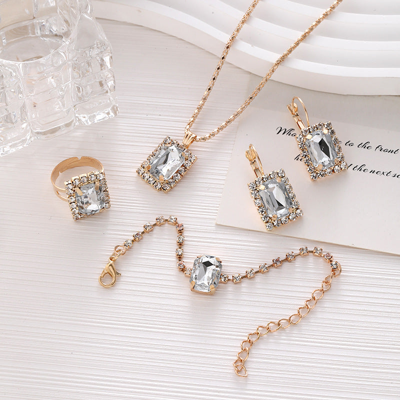 Luxuriöses Kristall-Statement-Schmuckset mit rechteckigem Halo-Anhänger, passenden hängenden Ohrringen, verstellbarem Tennisarmband und Statement-Cocktailring