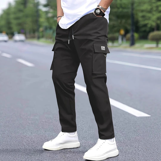 Herren Slim‑Tapered Cargo‑Jogginghose mit Tunnelzugbund, Klappentaschen und Metallringdetail Shop Nory