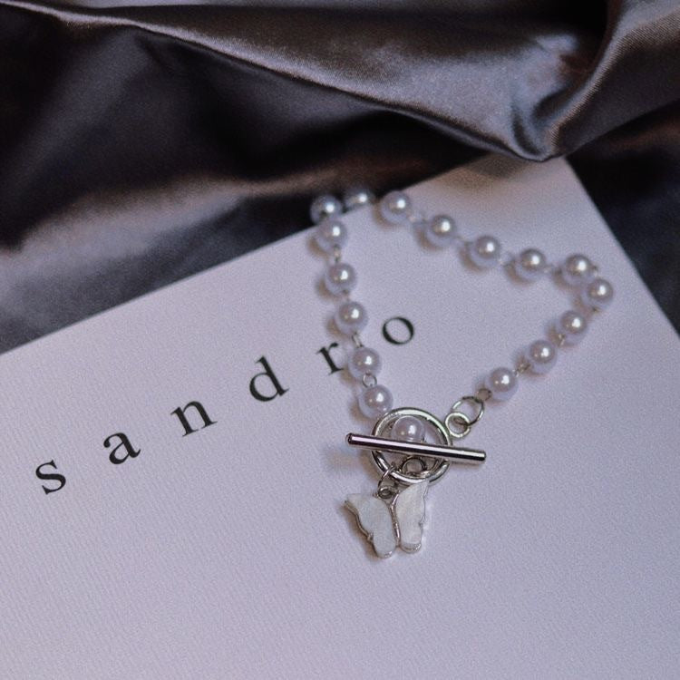 Damen Armband mit eleganten Süßwasserperlen und filigranem Schmetterlingsanhänger Shop Nory