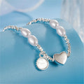 Damen Armband aus edlen Perlen mit herzförmigem Anhänger und funkelndem Element Shop Nory