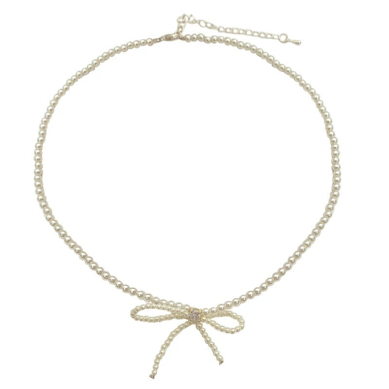 Damen Halskette mit elegantem Schleifenanhänger und zarten Perlendetails Shop Nory