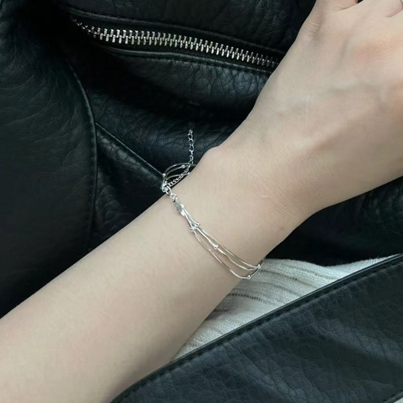 Damen stilvolles Armband mit geschwungenem Design und glänzenden Perlen Shop Nory
