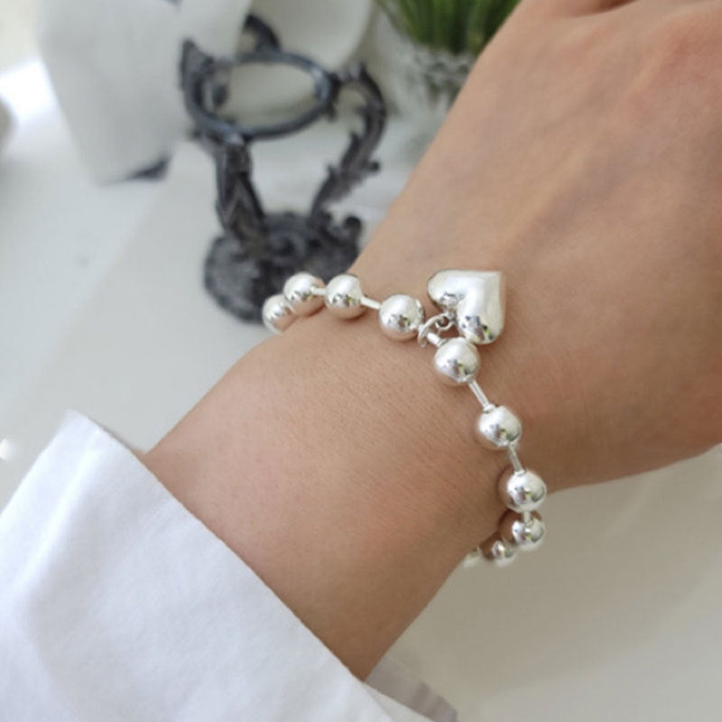 Damenarmband mit herzförmigem Anhänger und eleganten Perlen Shop Nory