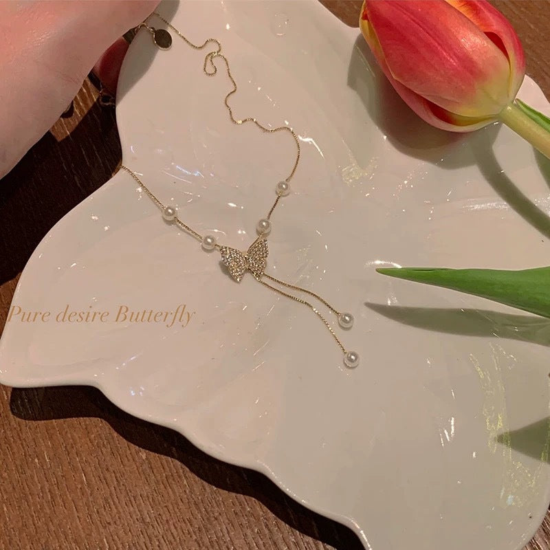 Damen Handkette mit funkelndem Schmetterlingsdesign und zarten Perlendetails Shop Nory