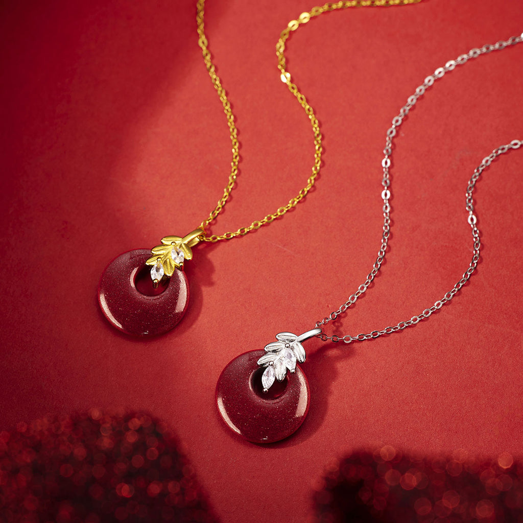 Damen Halskette mit kunstvollem runden Anhänger aus rotem Halbedelstein und goldenen Blätterdetails Shop Nory
