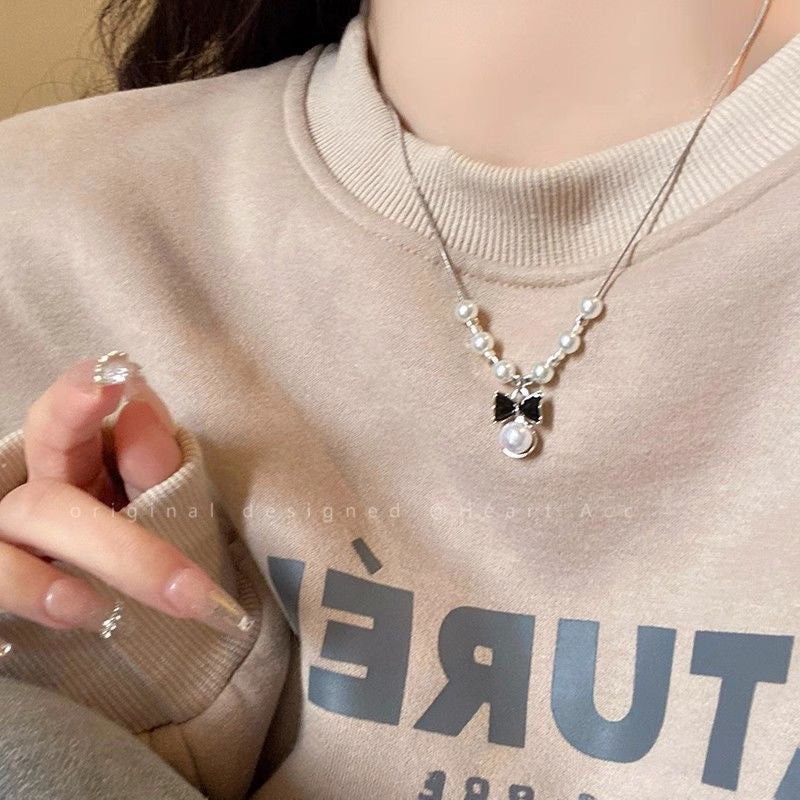 Damen Halskette mit verspieltem Schleifenanhänger und eleganten Perlen Shop Nory