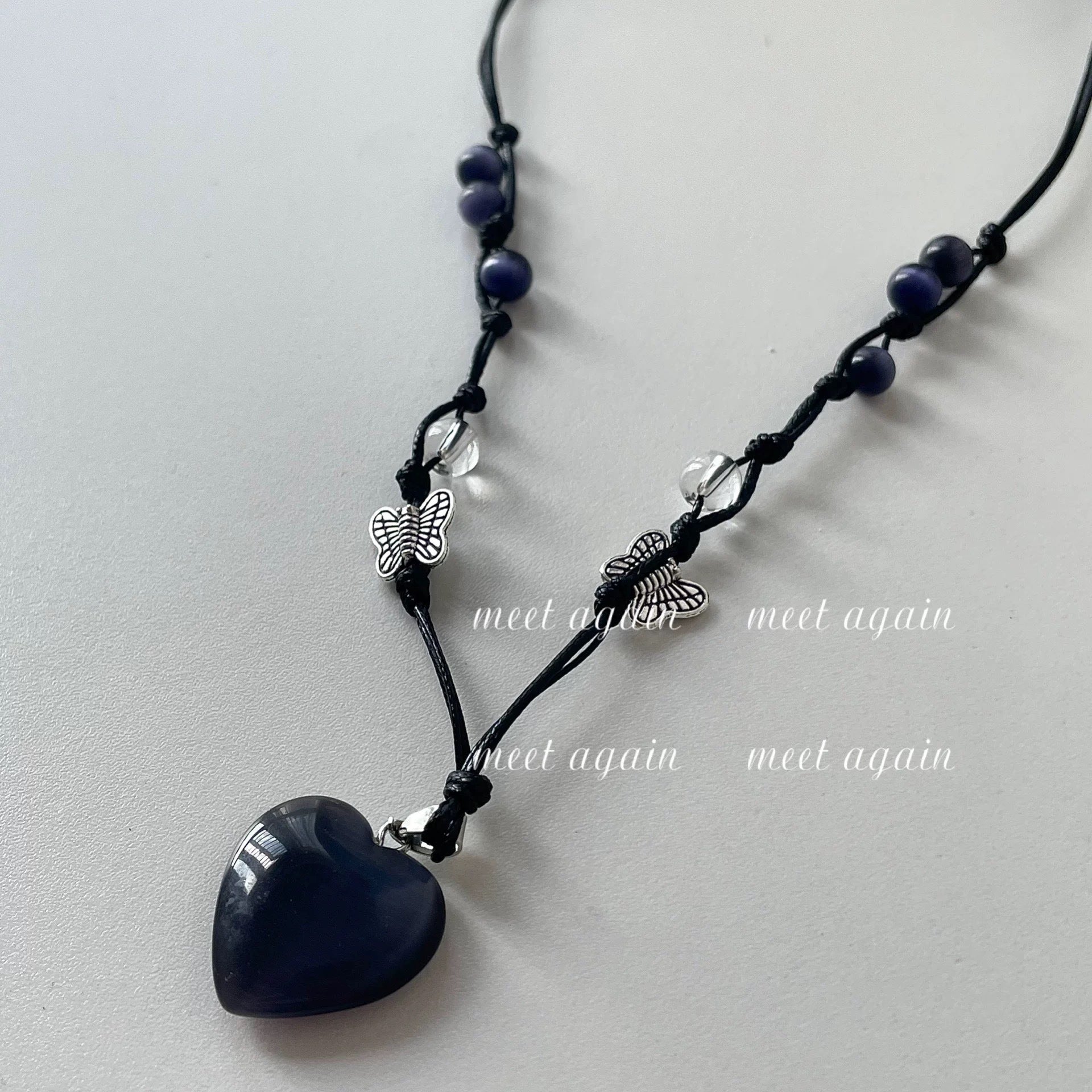 Damen Halskette mit herzförmigem Edelsteinanhänger und verspielten Schmetterlingsdetail Shop Nory