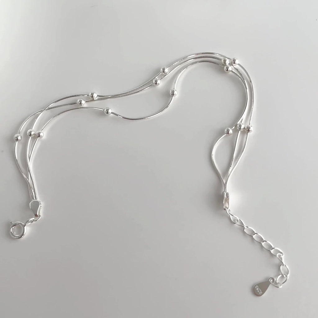 Damen stilvolles Armband mit geschwungenem Design und glänzenden Perlen Shop Nory
