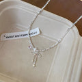 Damen Halskette mit zierlichem Schleifenanhänger und verspielten Perlen Shop Nory