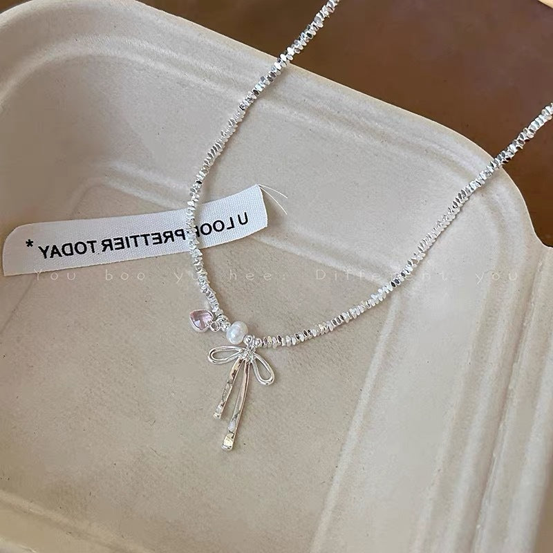 Damen Halskette mit zierlichem Schleifenanhänger und verspielten Perlen Shop Nory