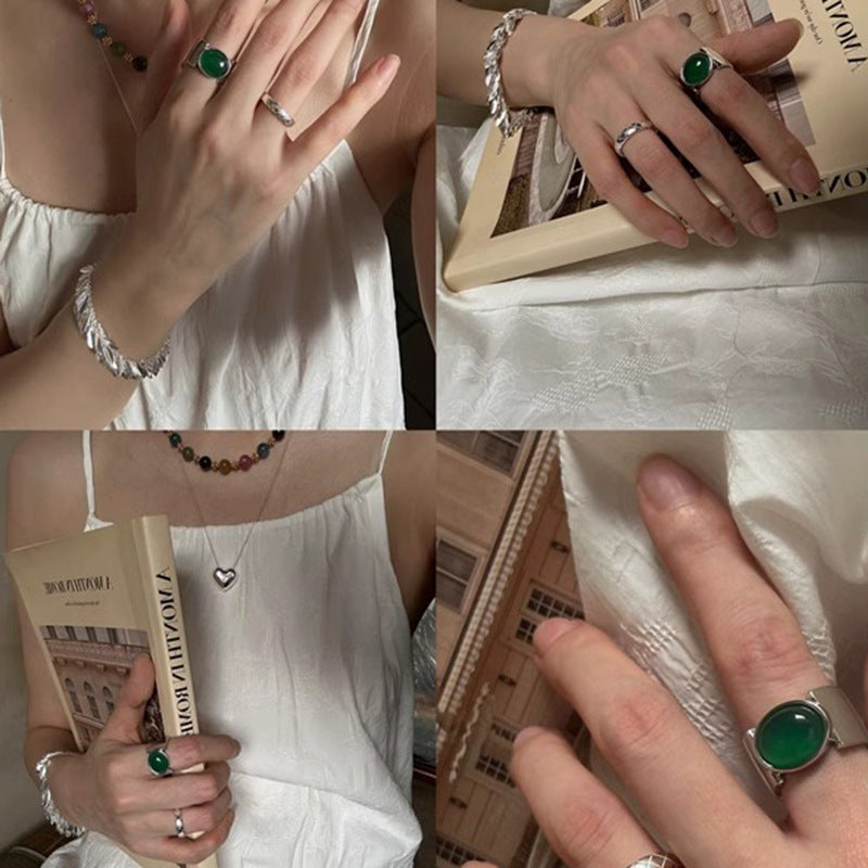 Damenring mit elegantem, geschwungenem Design und grünem Stein Shop Nory