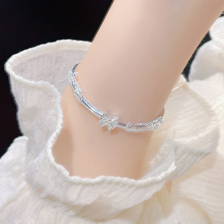 Damenarmreif mit floralem Design und verspieltem Schleifenanhänger Shop Nory
