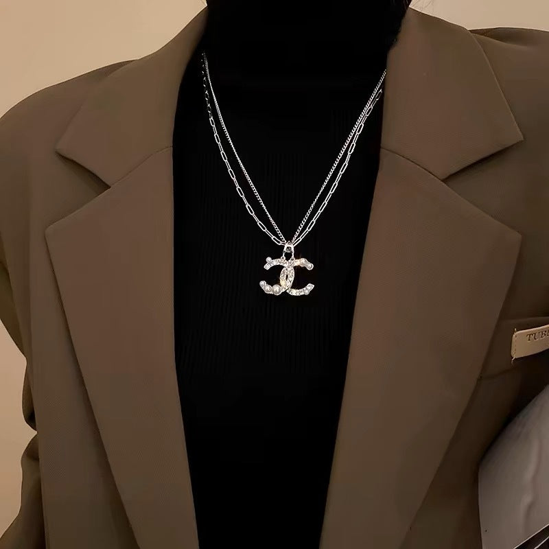 Damen Kette mit funkelndem Logoanhänger und Perlendetails Shop Nory
