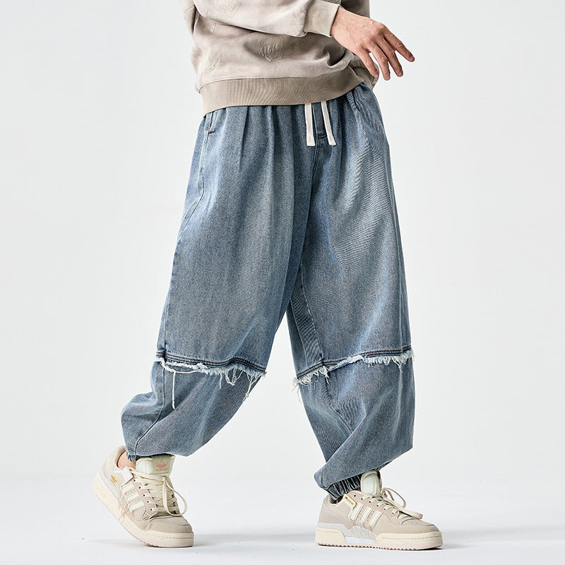 Herren Weit geschnittene Baggy-Denim-Hose mit Tunnelzug, elastischen Beinabschlüssen und Fransen-Detail Shop Nory