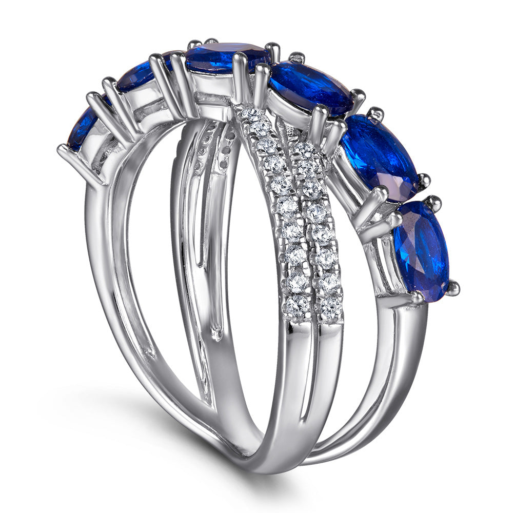 Damen Ring mit funkelnden blauen Zirkonia und eleganter, geschwungener Fassung Shop Nory