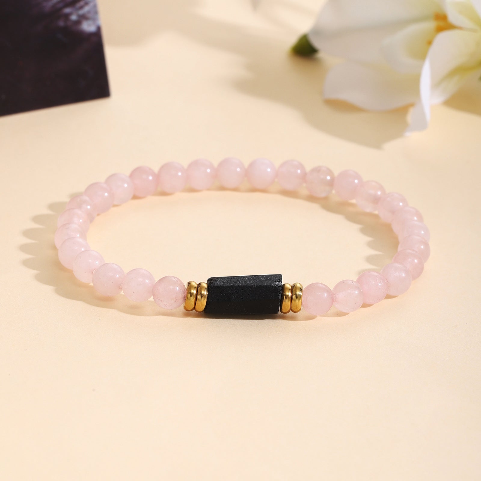 Damenarmband aus Rosenquarz mit schwarzem Akzent und goldenen Verzierungen Shop Nory