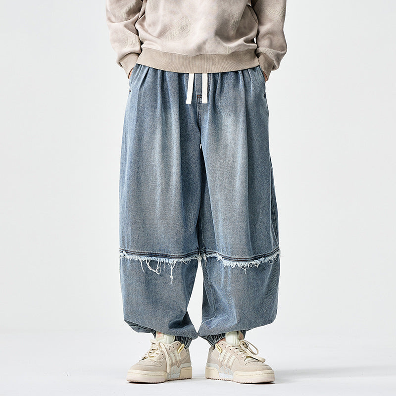Herren Weit geschnittene Baggy-Denim-Hose mit Tunnelzug, elastischen Beinabschlüssen und Fransen-Detail Shop Nory