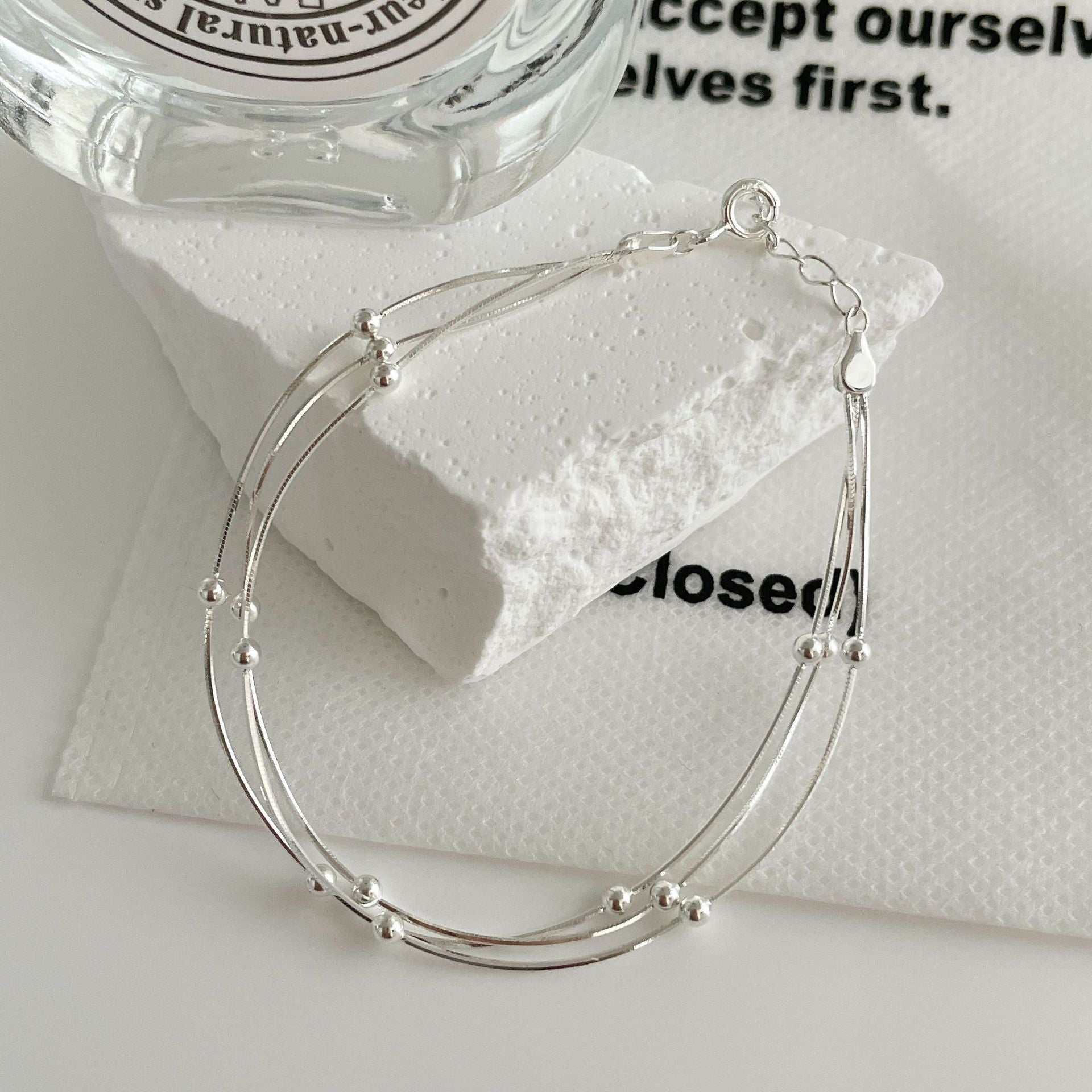 Damen stilvolles Armband mit geschwungenem Design und glänzenden Perlen Shop Nory
