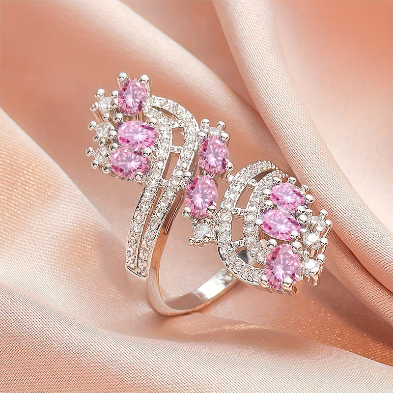 Damenring mit kunstvollem Wellenmuster und eleganten rosa Kristallen Shop Nory