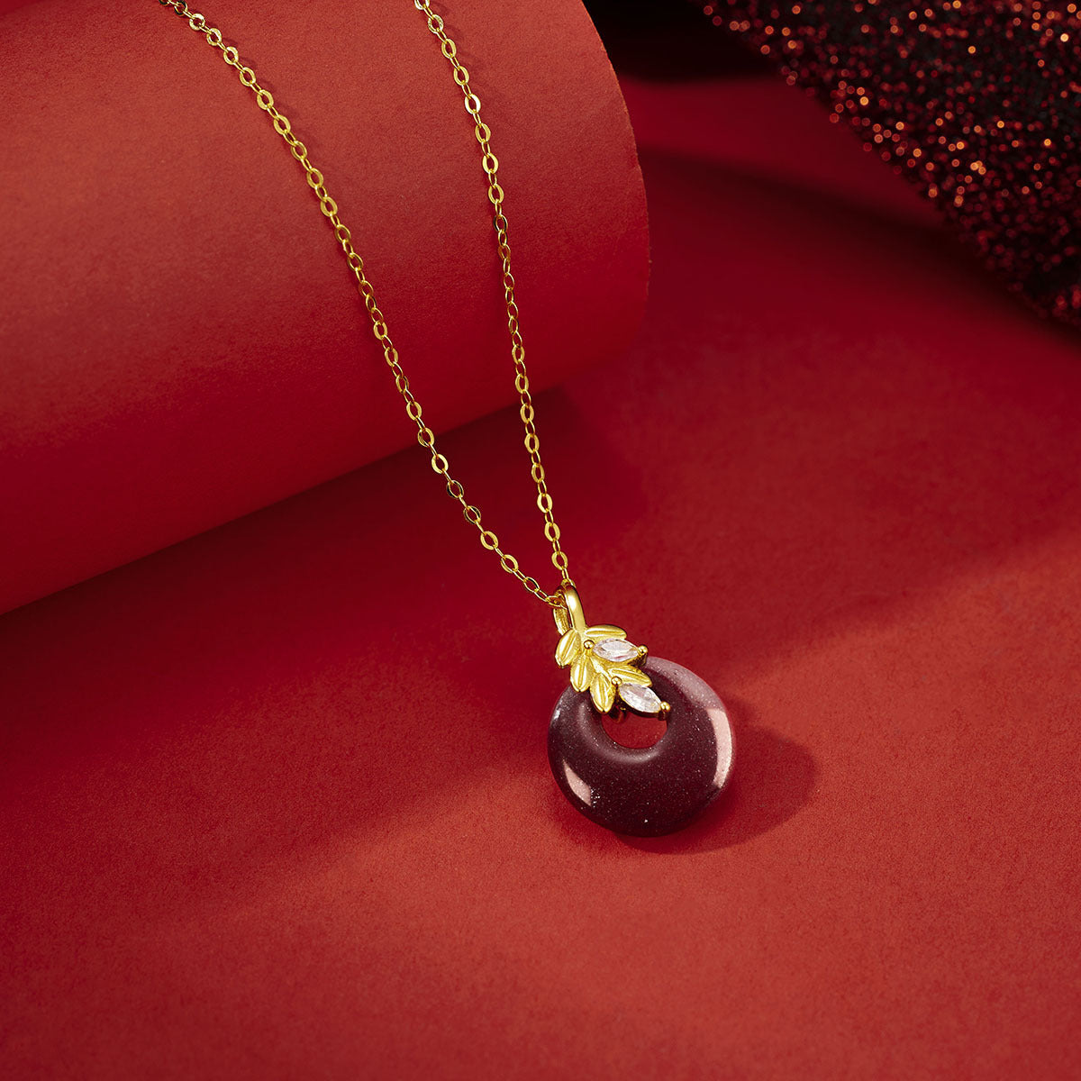 Damen Halskette mit kunstvollem runden Anhänger aus rotem Halbedelstein und goldenen Blätterdetails Shop Nory