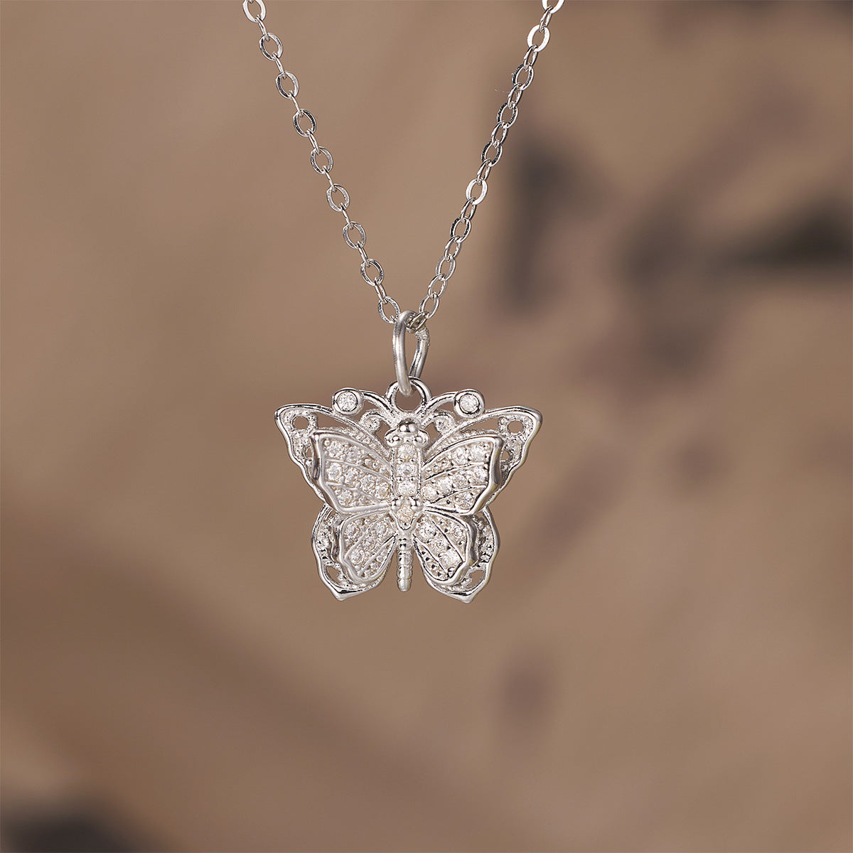 Damen Halskette mit kunstvollem Schmetterlingsanhänger aus goldfarbenem Metall und funkelnden Zirkonia Shop Nory