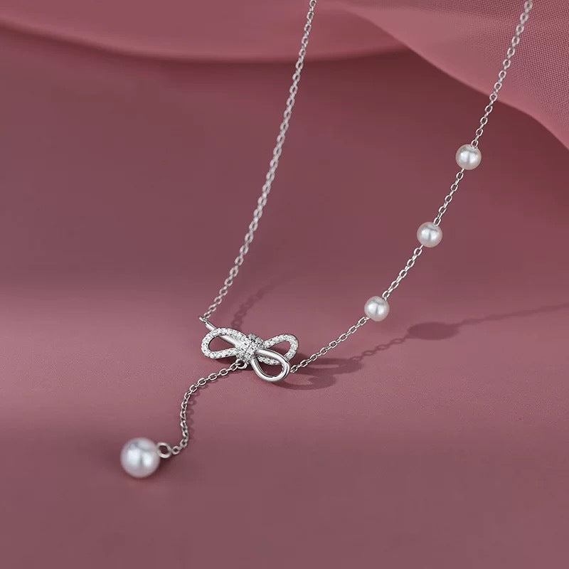Damen Halskette mit filigranem Schleifenanhänger und Perlendetails Shop Nory