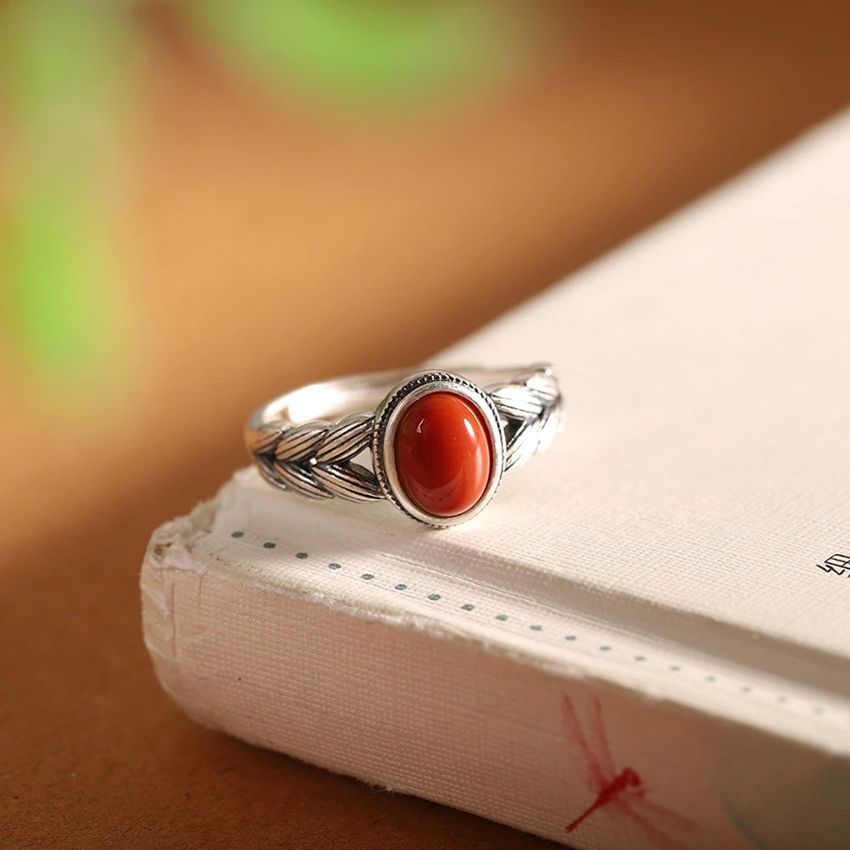 Damenring mit kunstvollem geflochtenem Design und rotem Zierstein Shop Nory