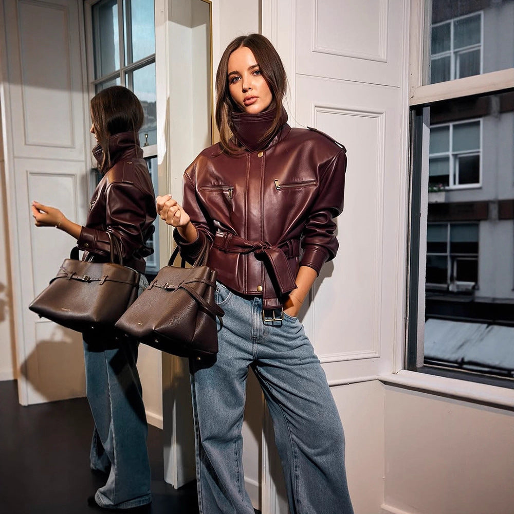 Damen Kurzjacke aus Kunstleder mit hohem Stehkragen, tailliertem Bindegürtel und markanten Schulterpolstern Shop Nory