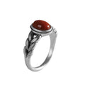 Damenring mit kunstvollem geflochtenem Design und rotem Zierstein Shop Nory