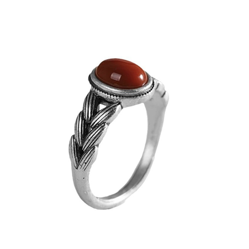Damenring mit kunstvollem geflochtenem Design und rotem Zierstein Shop Nory