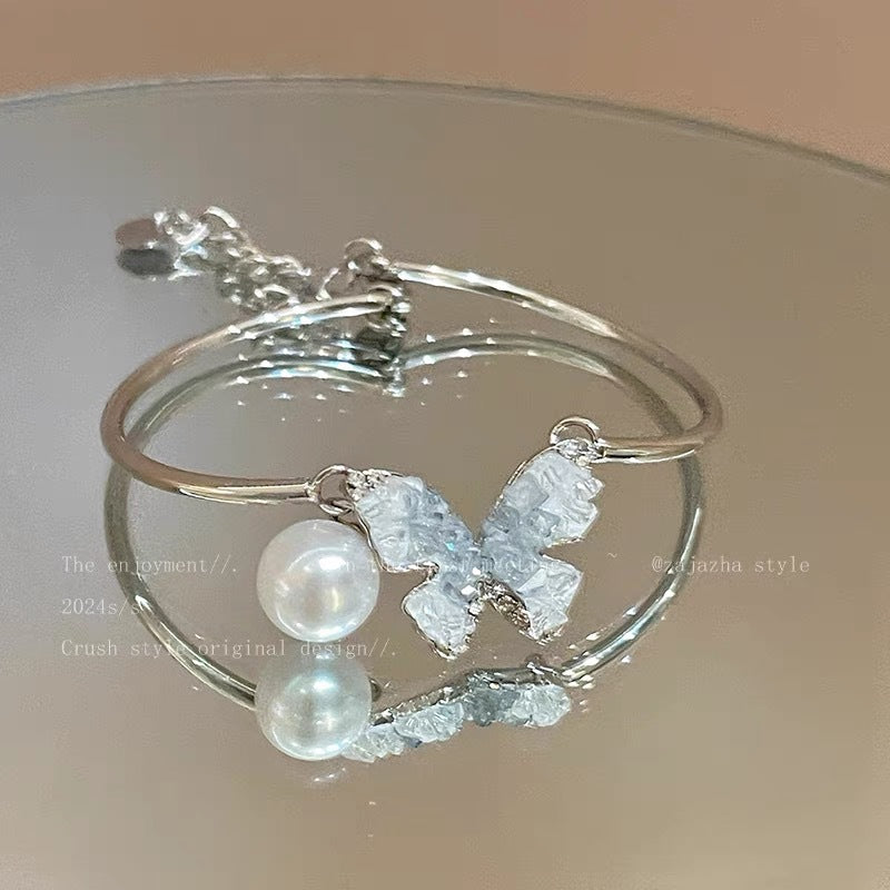 Damen Armband mit filigranen Schmetterlingsanhängern und eleganten Perlen Shop Nory