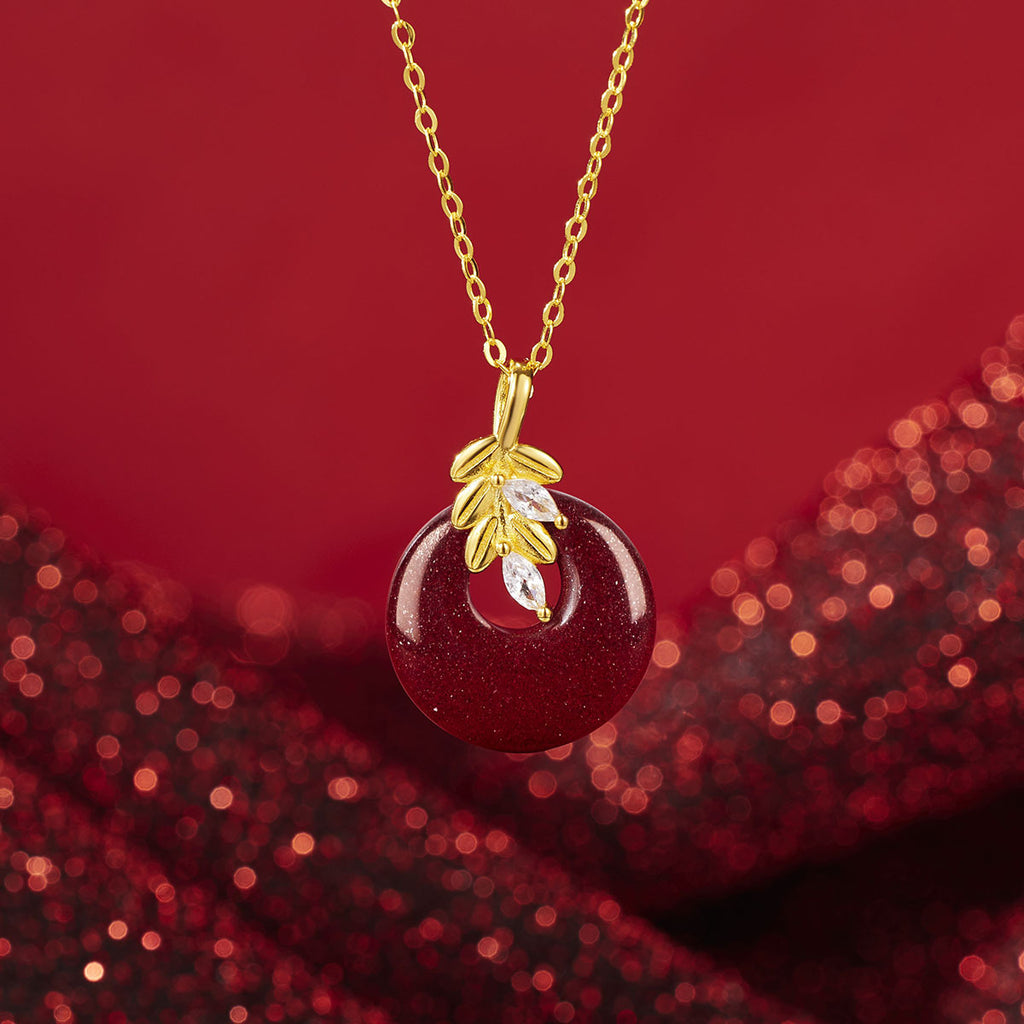 Damen Halskette mit kunstvollem runden Anhänger aus rotem Halbedelstein und goldenen Blätterdetails Shop Nory