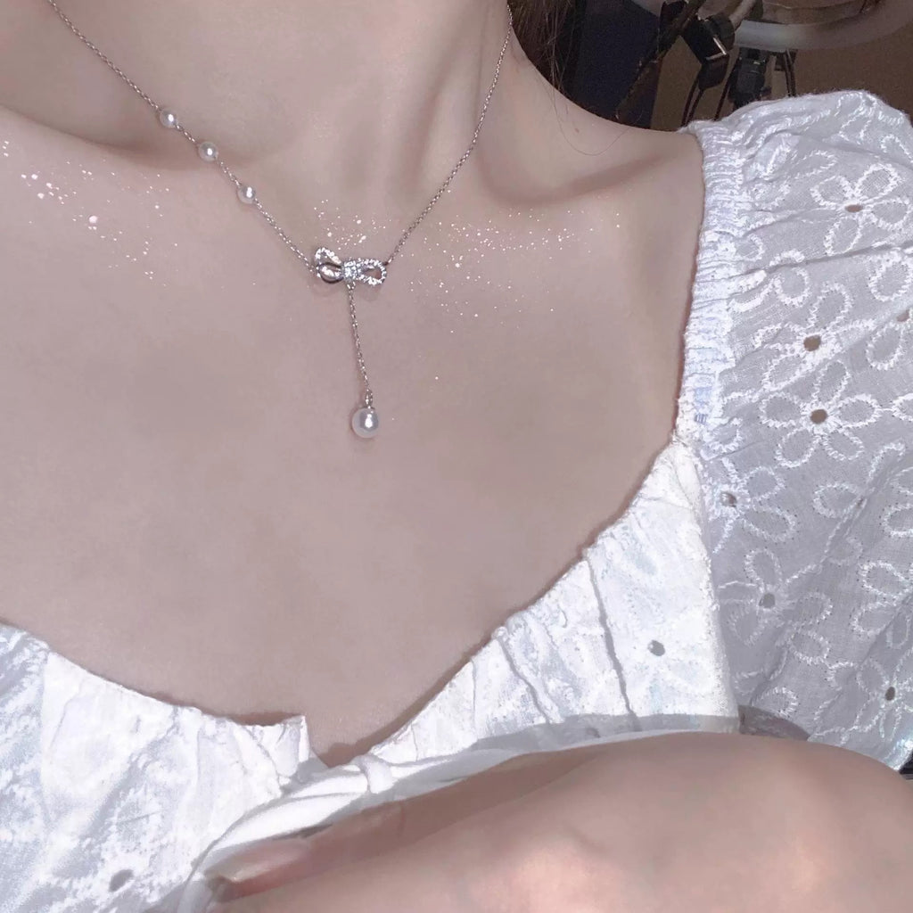 Damen Halskette mit filigranem Schleifenanhänger und Perlendetails Shop Nory