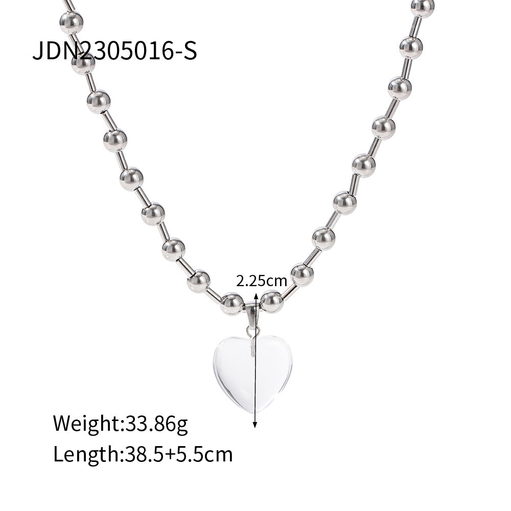 Damen Halskette mit transparentem Herzanhänger und goldene Kugel-Details Shop Nory