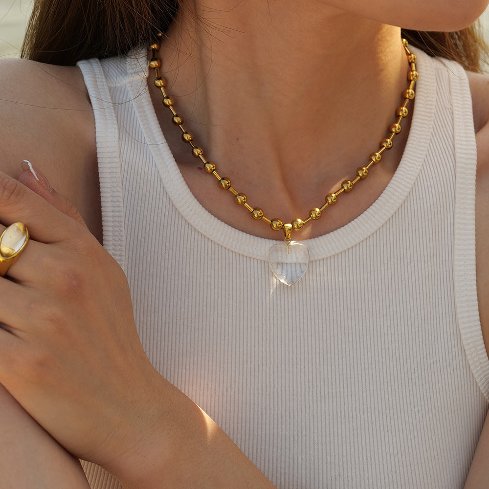 Damen Halskette mit transparentem Herzanhänger und goldene Kugel-Details Shop Nory