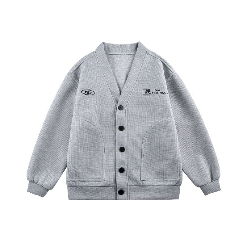 Unisex Boxy-Strickjacke im Waffelstrick mit V-Kragen, durchgehender Knopfleiste und aufgesetzten Rundtaschen Shop Nory