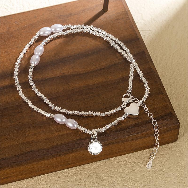 Damen Armband aus edlen Perlen mit herzförmigem Anhänger und funkelndem Element Shop Nory