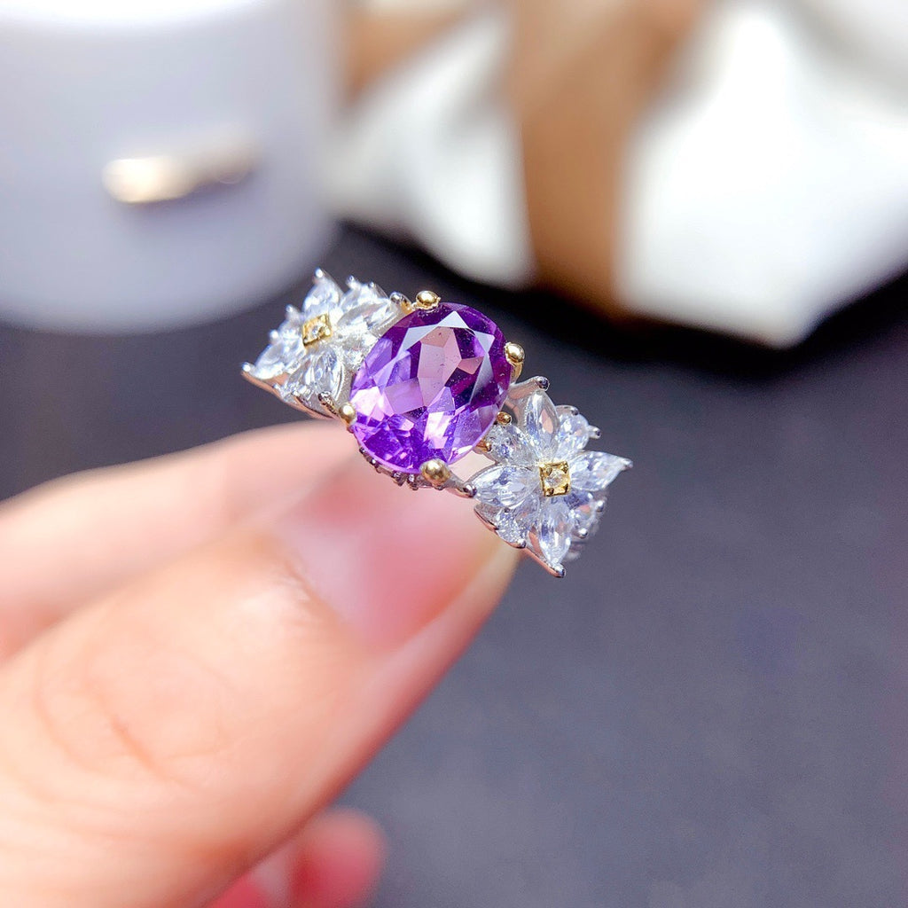 Damenring mit facettiertem lila Edelstein und floralem Design Shop Nory