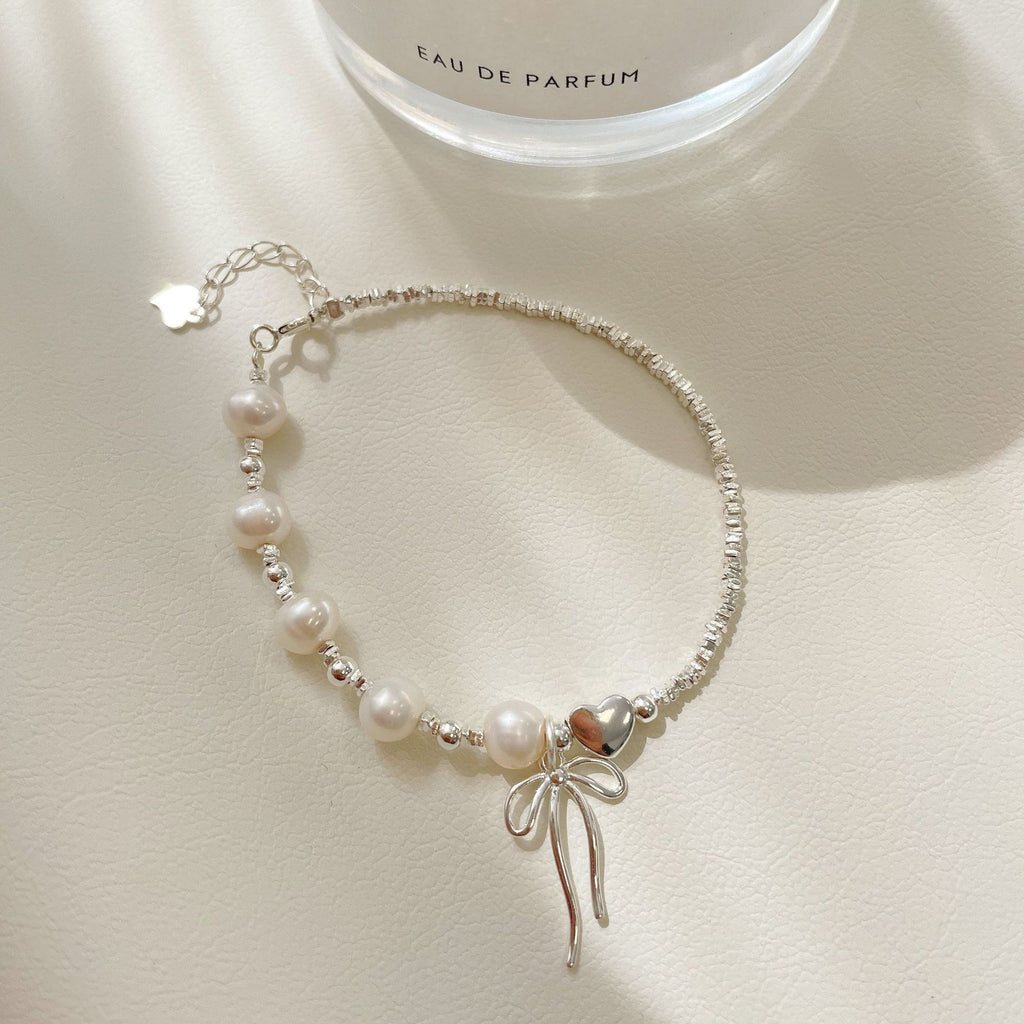 Damen Schmuckarmband mit filigranem Schleifenanhänger und hochwertigen Perlen Shop Nory