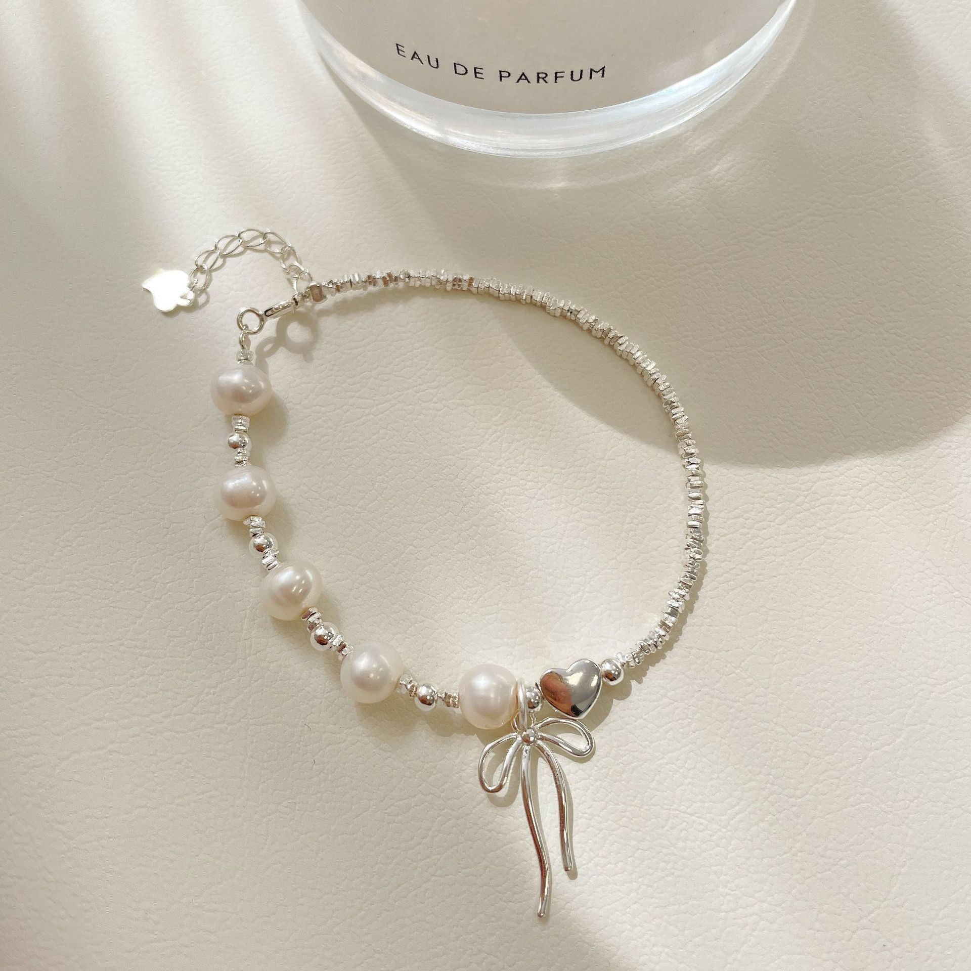 Damen Schmuckarmband mit filigranem Schleifenanhänger und hochwertigen Perlen Shop Nory