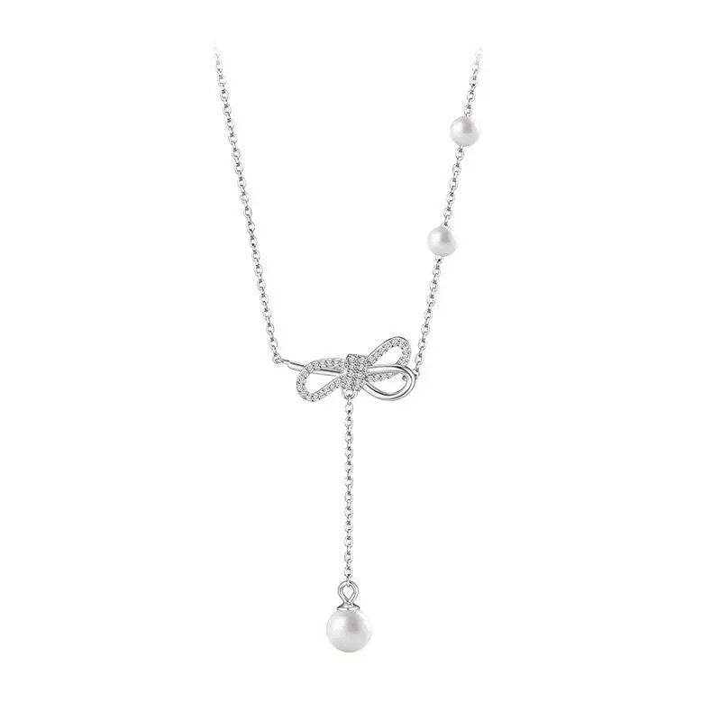 Damen Halskette mit filigranem Schleifenanhänger und Perlendetails Shop Nory