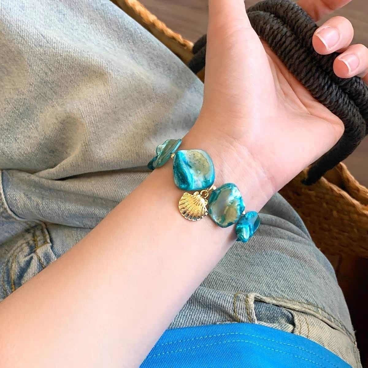 Damen Armband aus großen Muschelperlen und eleganten Anhängern Shop Nory