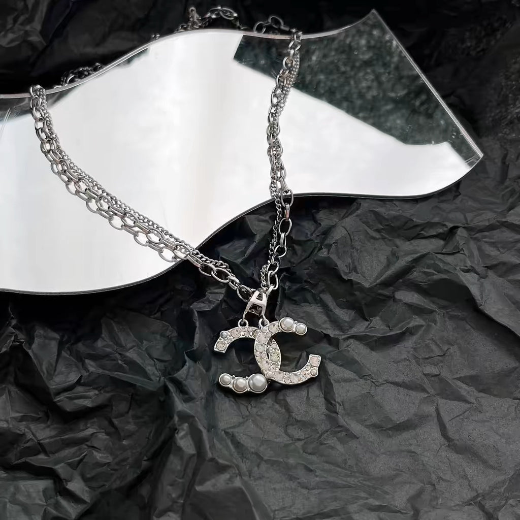 Damen Kette mit funkelndem Logoanhänger und Perlendetails Shop Nory