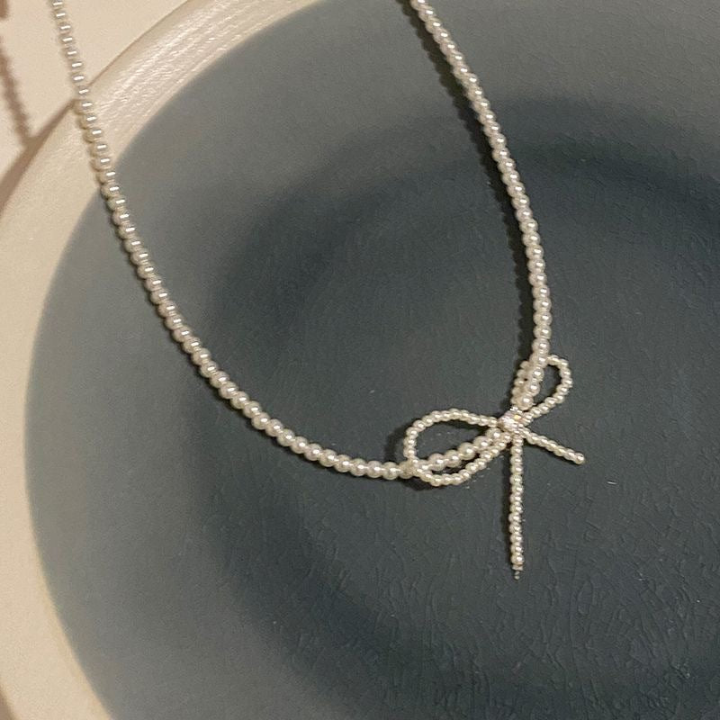 Damen Halskette mit elegantem Schleifenanhänger und zarten Perlendetails Shop Nory