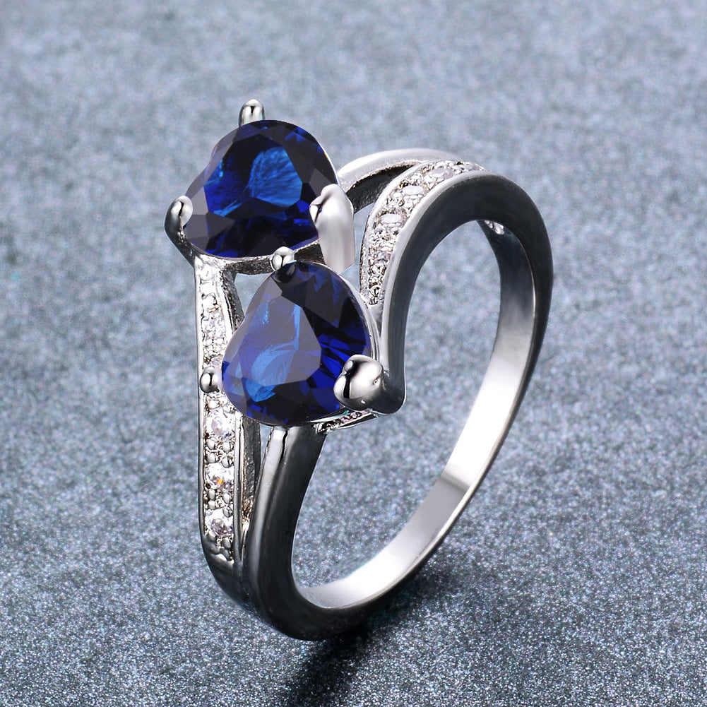 Damen Ring mit zwei herzförmigen blauen Zirkonen und funkelnden Zirkonia-Details Shop Nory