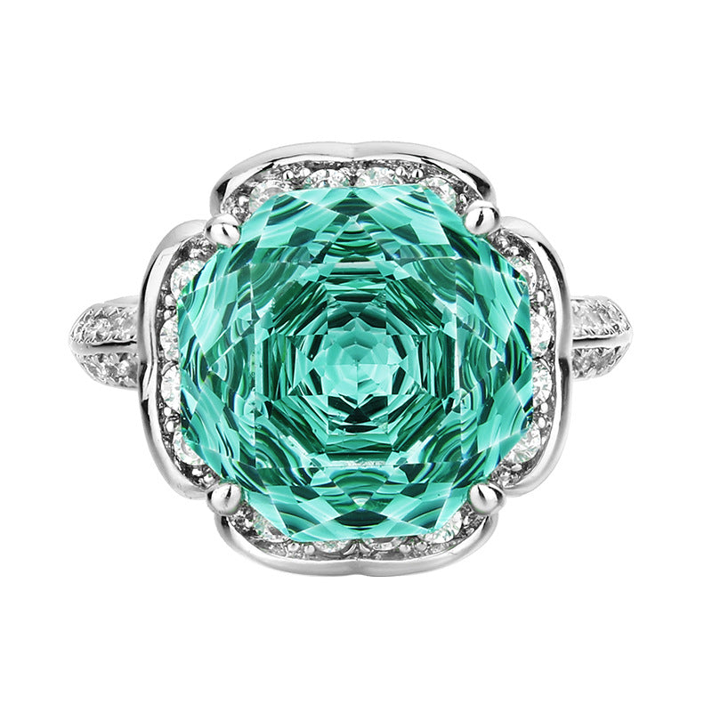Luxuriöser Cocktailring aus Sterlingsilber mit Halo, großem facettiertem synthetischen Edelstein und Pavé-Band