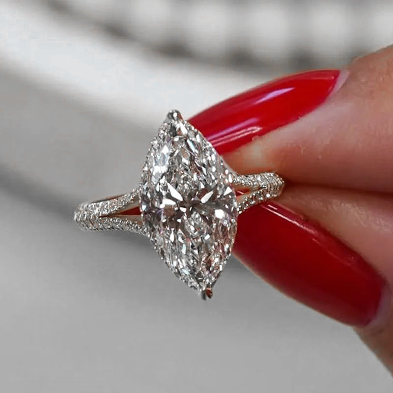 Damen exklusiver Verlobungsring mit funkelndem Marquise-Edelstein und zarten Zirkonia-Verzierungen Shop Nory