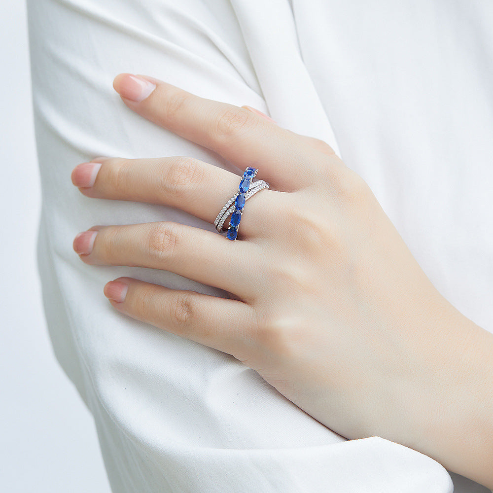 Damen Ring mit funkelnden blauen Zirkonia und eleganter, geschwungener Fassung Shop Nory